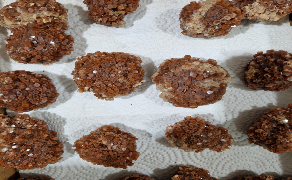 Natural aragonite star cluster with earthy brown crystals radiating in a symmetrical formation