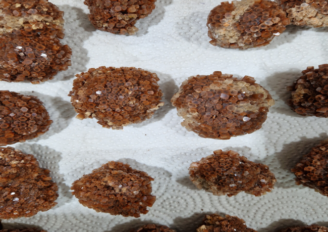 Natural aragonite star cluster with earthy brown crystals radiating in a symmetrical formation