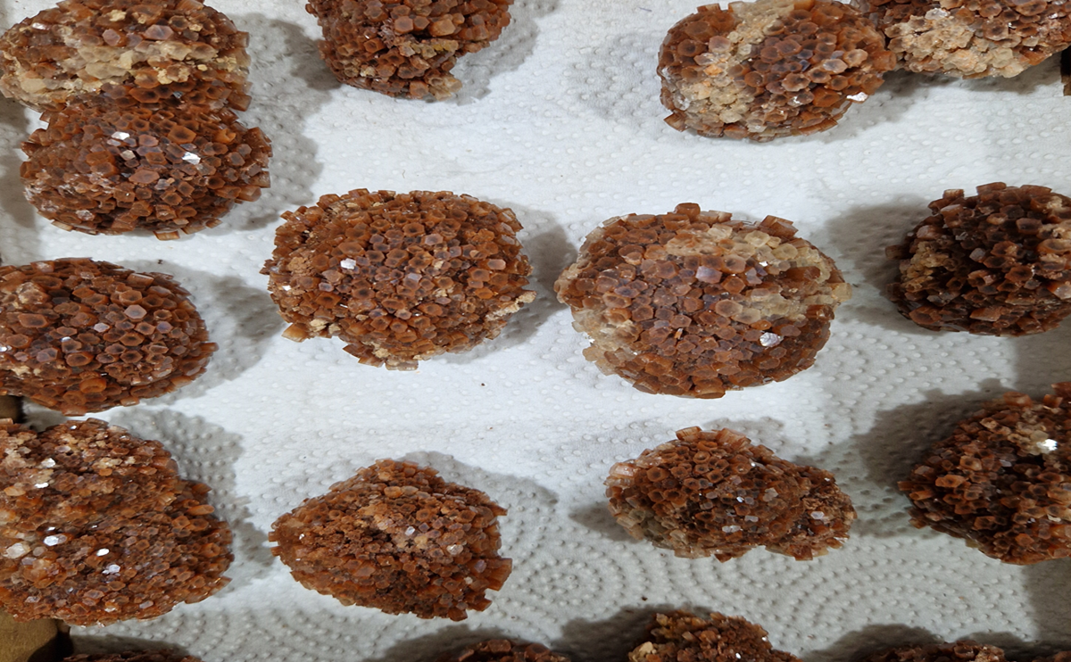 Natural aragonite star cluster with earthy brown crystals radiating in a symmetrical formation